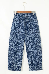 Blue patterned pants on a hanger against a white background