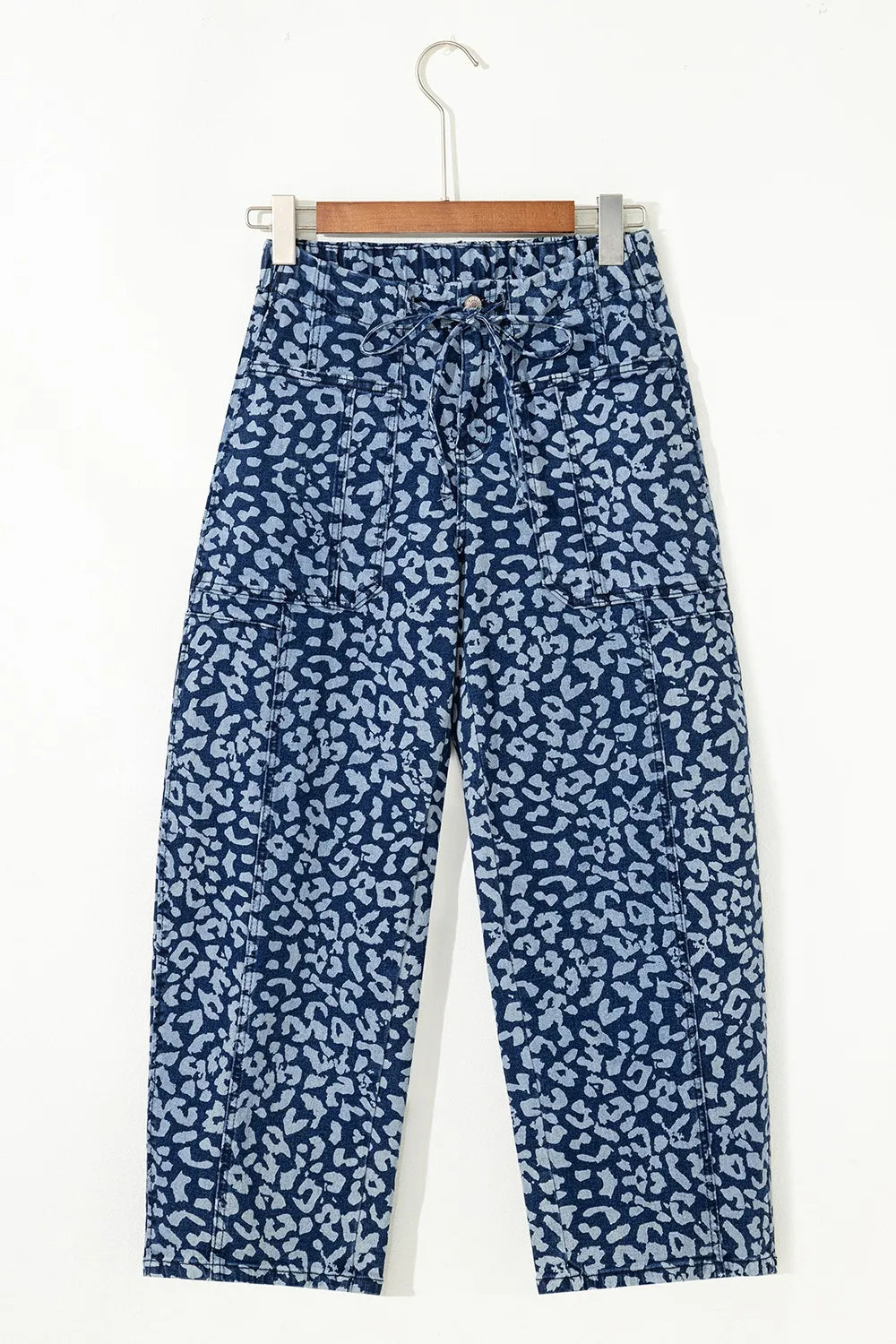 Blue patterned pants on a hanger against a white background