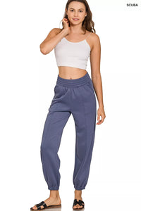 Woman wearing blue pants and a white top on a white background