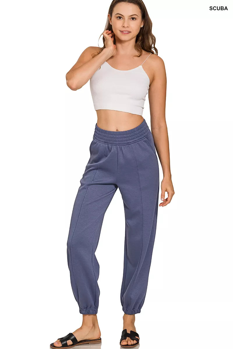 Woman wearing blue pants and a white top on a white background