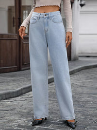 Person wearing light blue jeans on a street.
