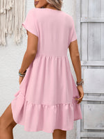 Pink dress worn by a person against a light wooden panel background