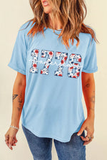 Woman wearing a light blue t-shirt with '1776' design on a beige background