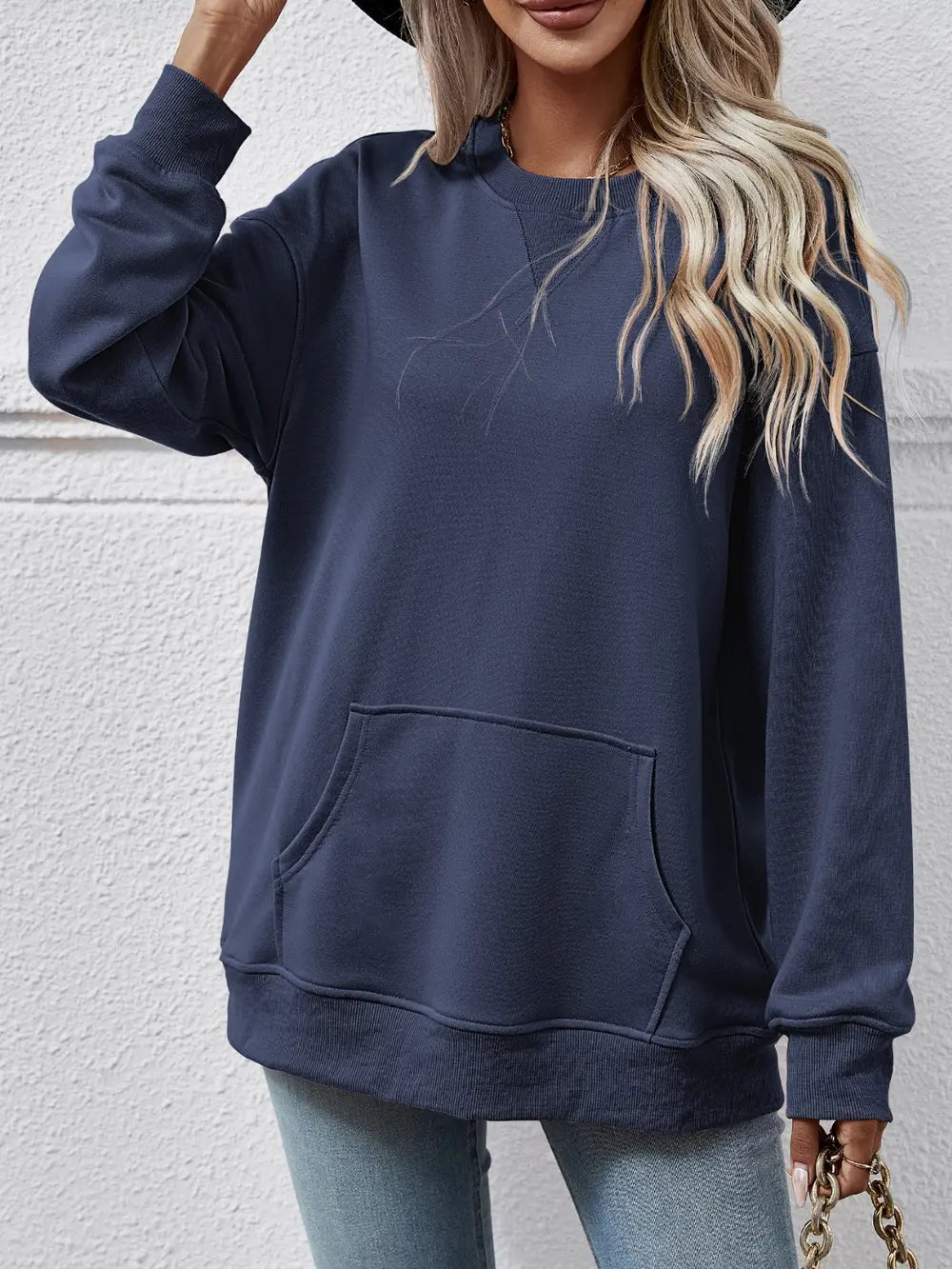 Person wearing a navy blue sweatshirt with a plain background
