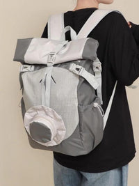 Person wearing a gray and white backpack against a plain background