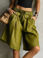 A woman wearing green High-Waisted Drawstring Shorts with her hands in both pockets