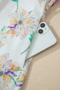 Smartphone with a floral case on a sandy surface