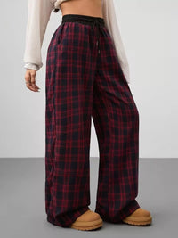 Plaid pants worn by a person on a plain background