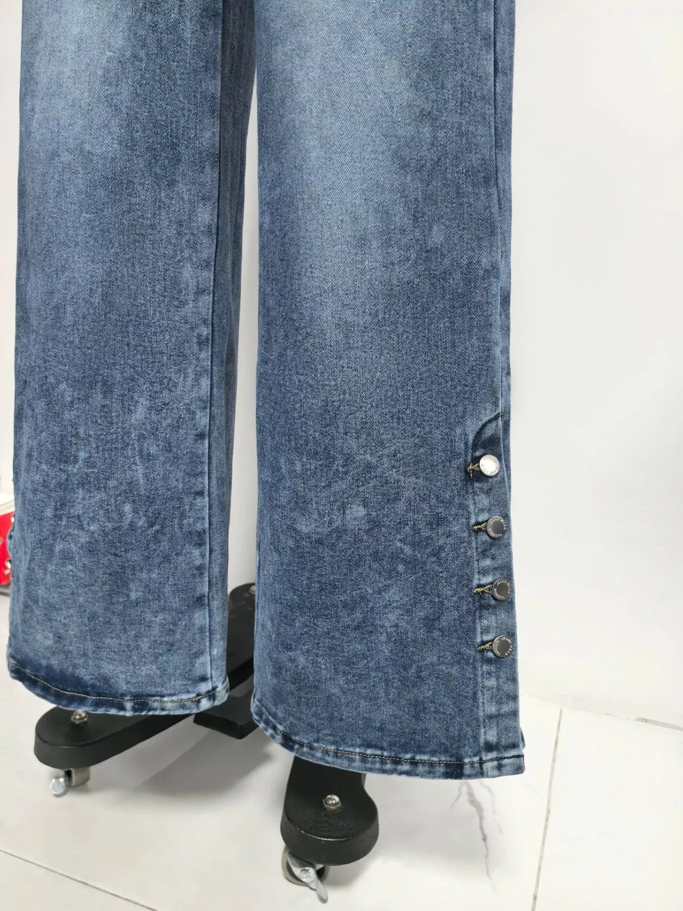 Blue acid-wash jeans on a stand against a white background
