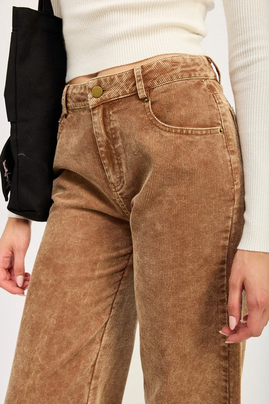 Brown corduroy pants worn by a person on a plain background