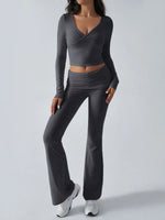 Person wearing a gray long-sleeve crop top and flared pants on a light gray background