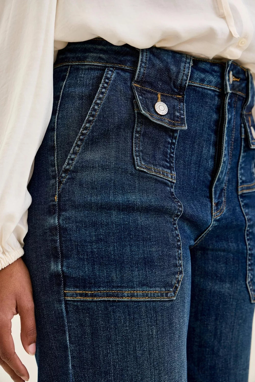 Close-up of blue jeans with a white shirt underneath