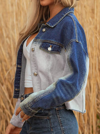 Person wearing a blue denim jacket over a white top with a blurred natural background