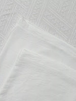 Close-up of textured white fabric with geometric pattern