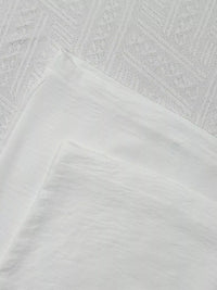 Close-up of textured white fabric with geometric pattern