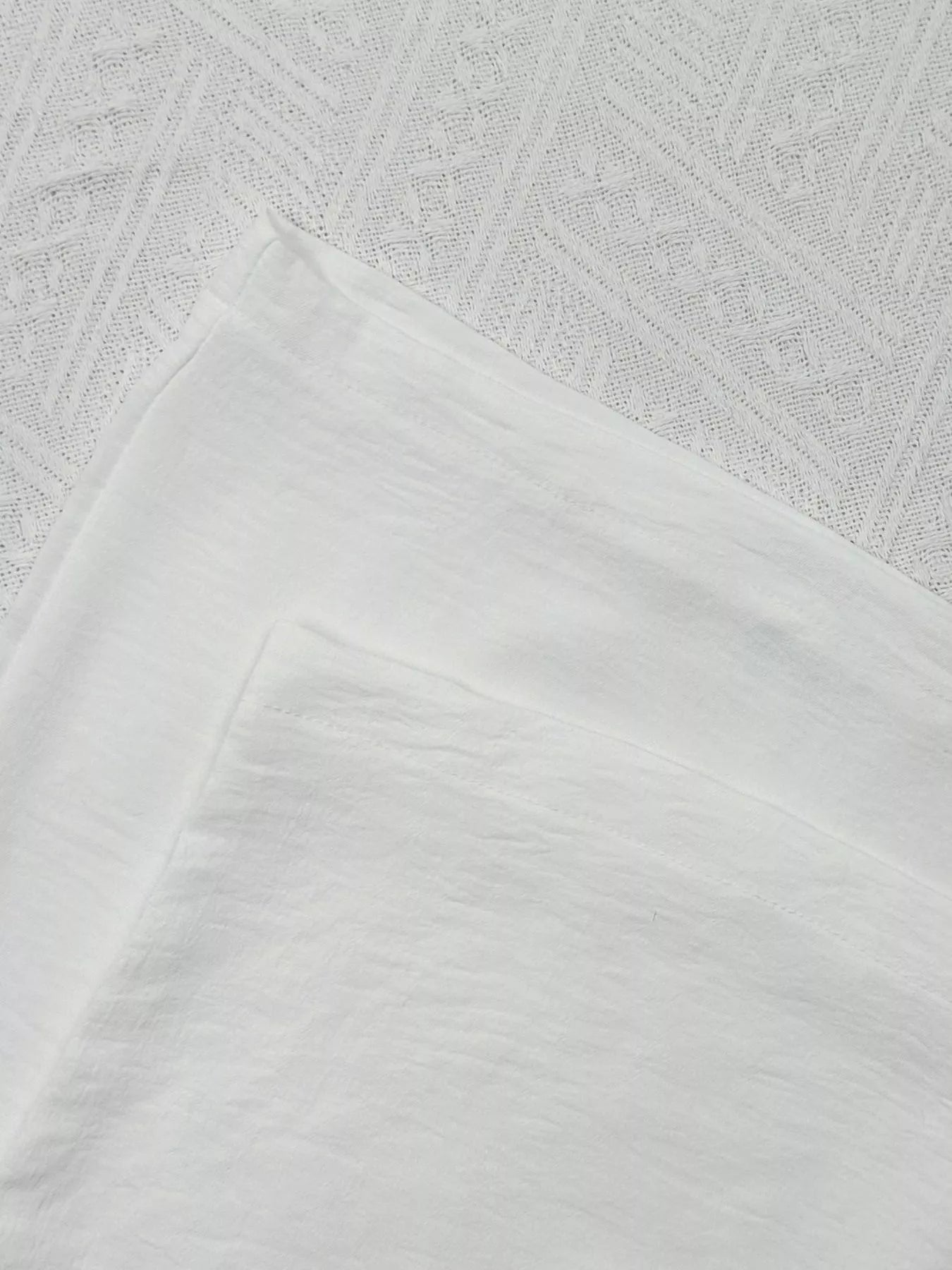 Close-up of textured white fabric with geometric pattern
