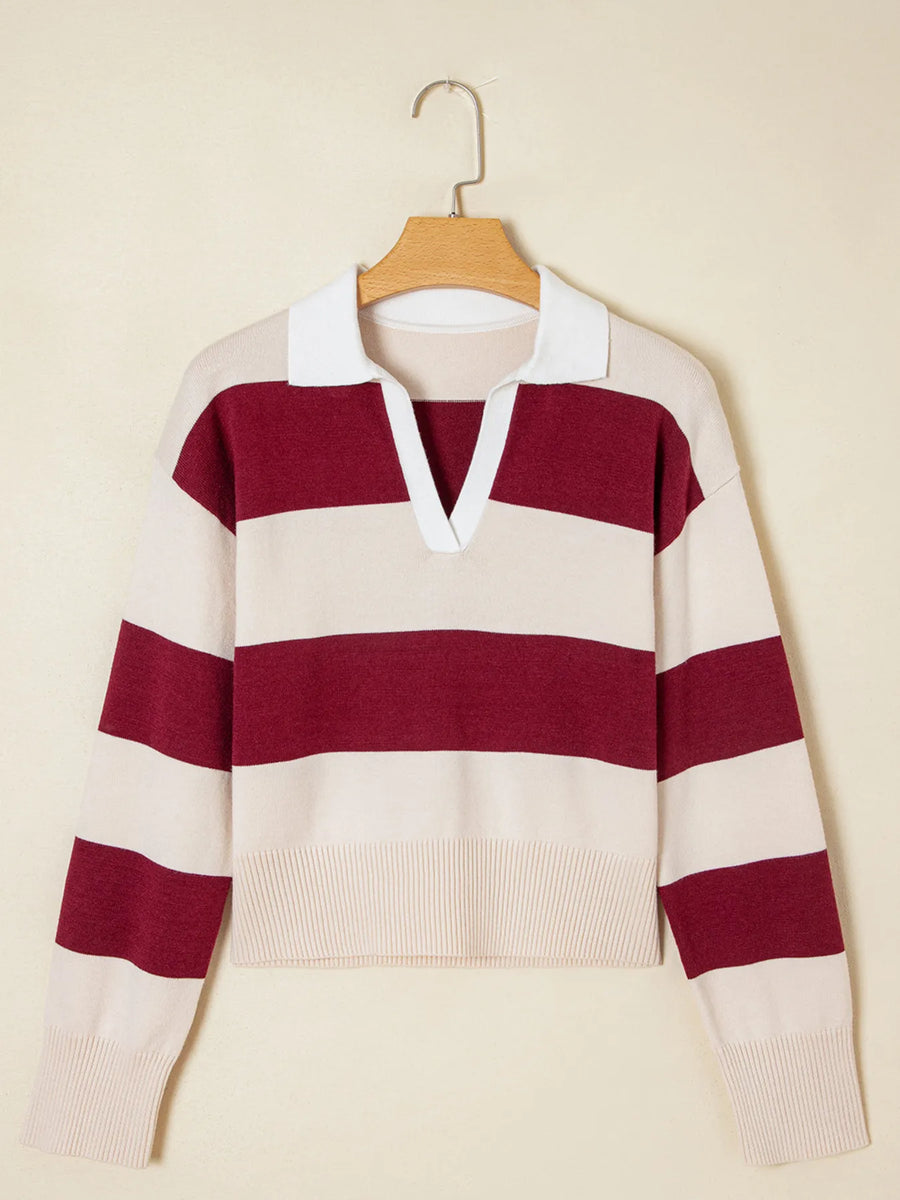 Beige and burgundy striped sweater on a hanger against a beige background