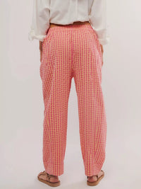 Person wearing red and yellow checkered pants on a white background