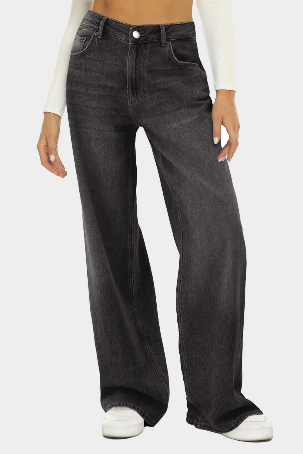 Person wearing black wide-leg jeans on a white background