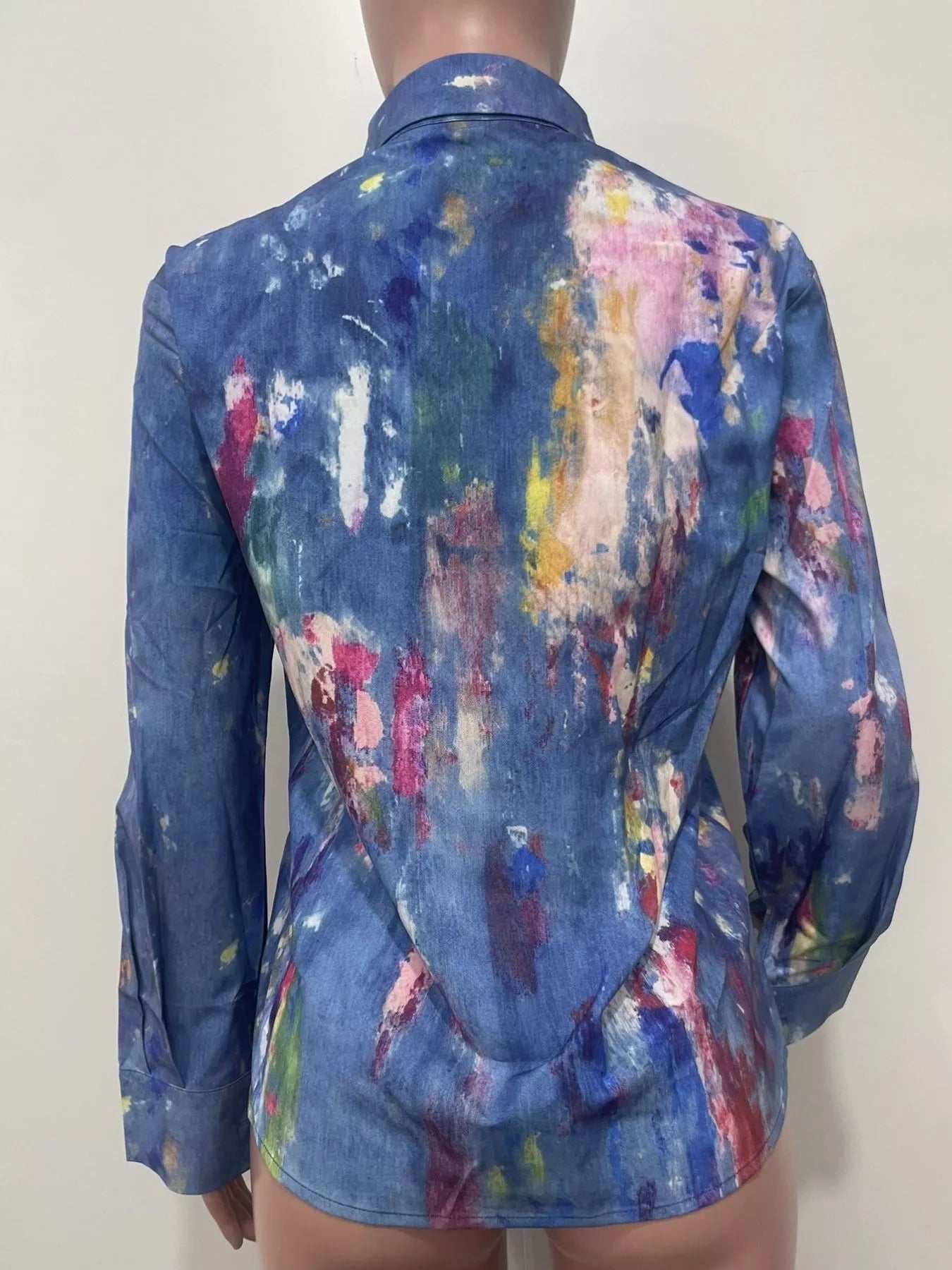 Mannequin wearing a colorful, abstract-patterned shirt against a plain background