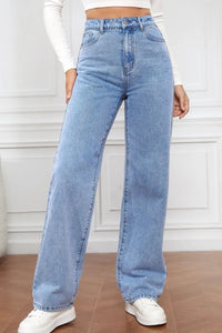 Person wearing light blue jeans with a white background