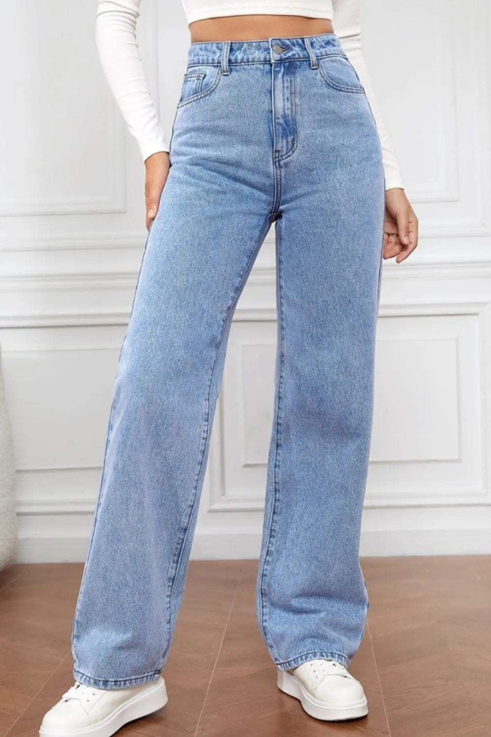 Person wearing light blue jeans with a white background