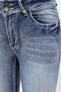 Close-up of blue jeans with a focus on the waistband and front pocket.