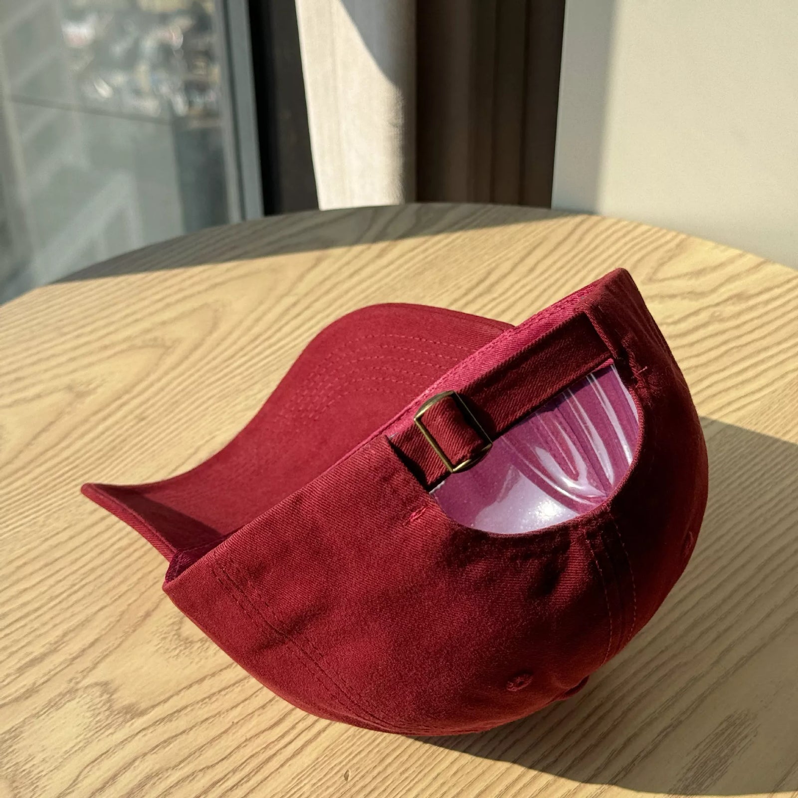 Red velvet bag with a pink interior on a wooden surface