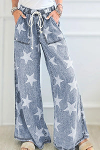 Blue denim pants with star pattern worn by a person indoors.