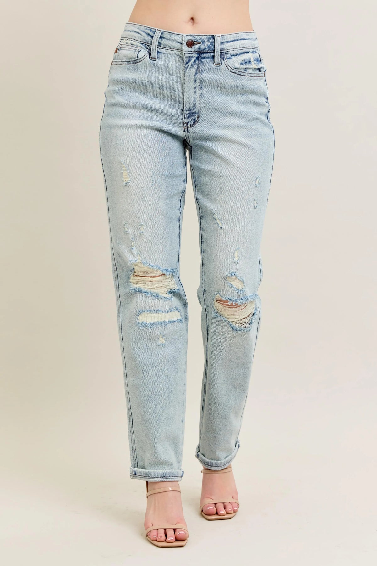 Light blue distressed jeans on a beige background