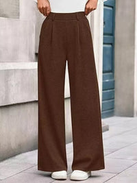 Brown wide-leg pants worn by a person standing against a neutral background