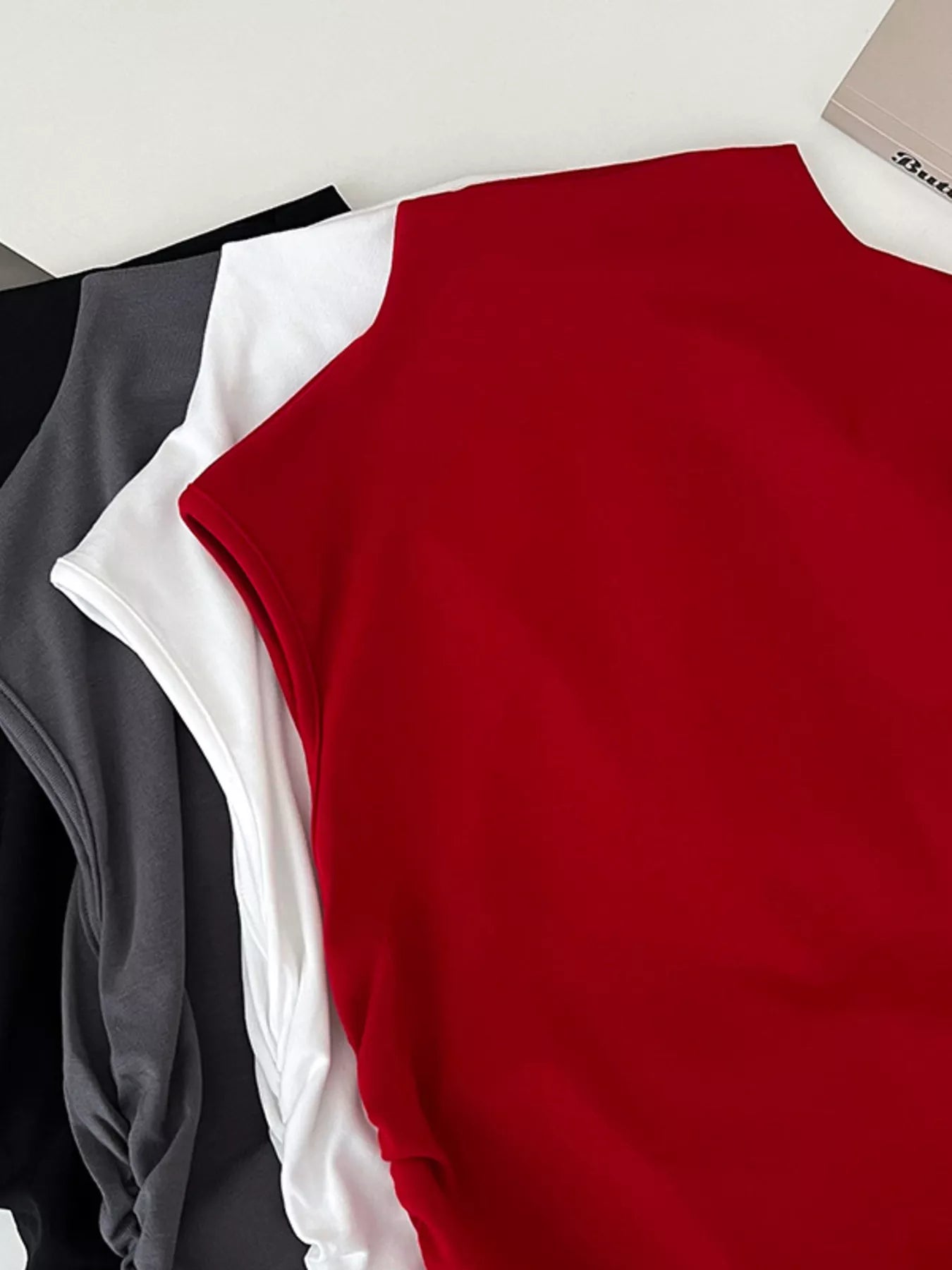 Red, white, and black sleeveless top on a light gray background
