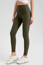 Person wearing olive green leggings and white sneakers on a light gray background