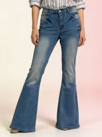 Flared jeans worn by a person on a light pink background