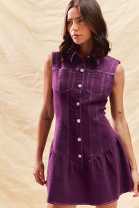 Woman wearing a purple dress with a beige background