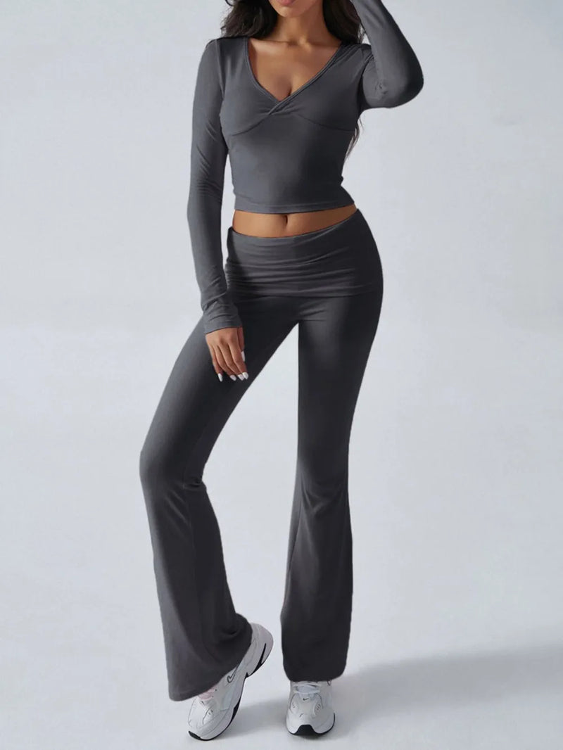 Woman wearing a gray long-sleeve top and pants on a white background