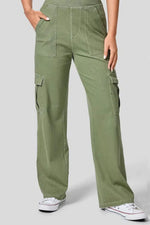 Person wearing green cargo pants on a plain background