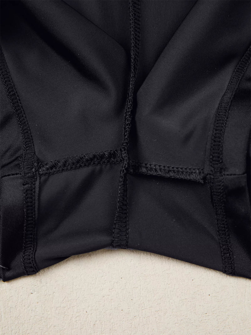 Close-up of a black jacket with a textured pattern on a beige surface