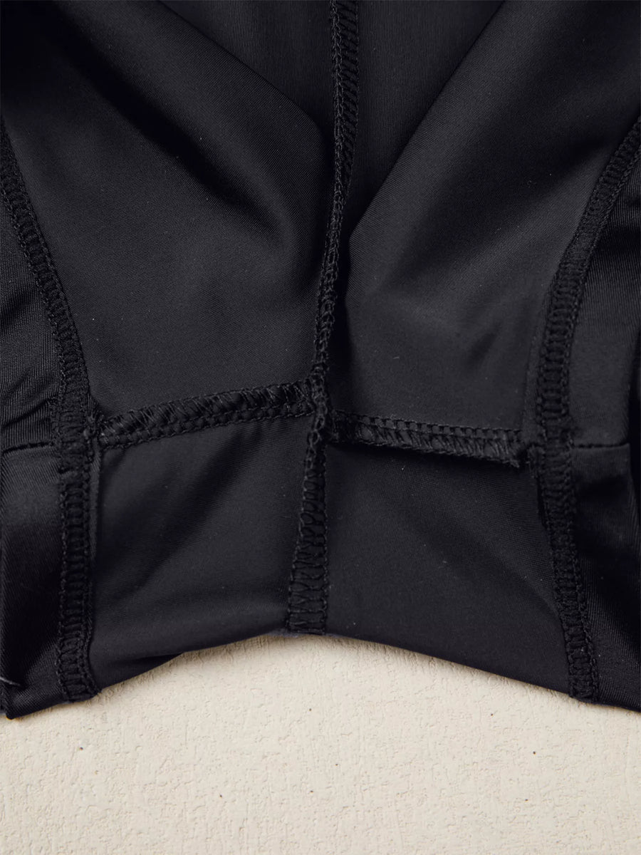 Close-up of a black jacket with a textured pattern on a beige surface