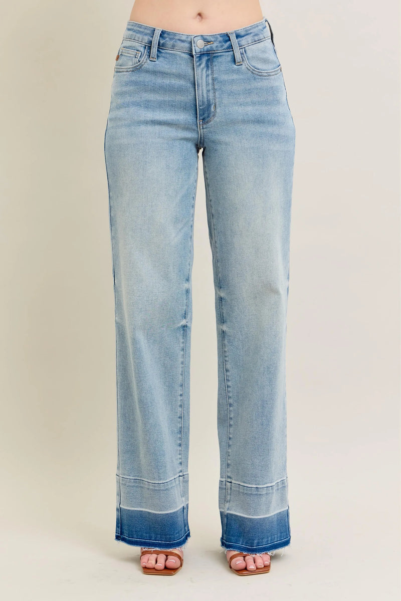 Light blue jeans with a rolled hem on a beige background