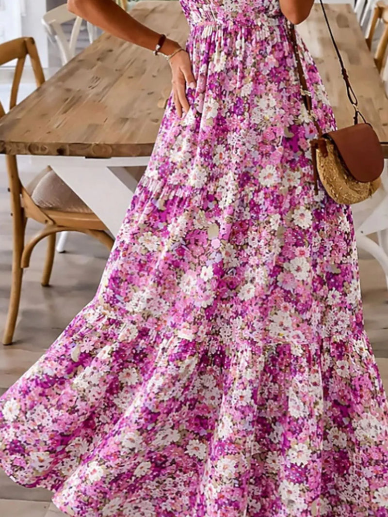 Person wearing a floral dress with a wooden table and chairs in the background