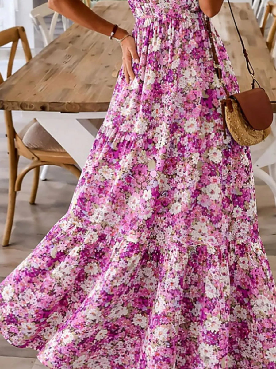 Person wearing a floral dress with a wooden table and chairs in the background