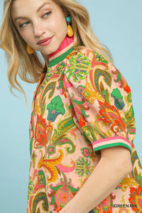 Woman wearing a colorful patterned dress against a light blue background