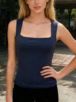 Woman wearing a navy blue tank top outdoors.