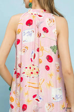 Light pink sleeveless dress with colorful fruit and cake pattern on a light blue background