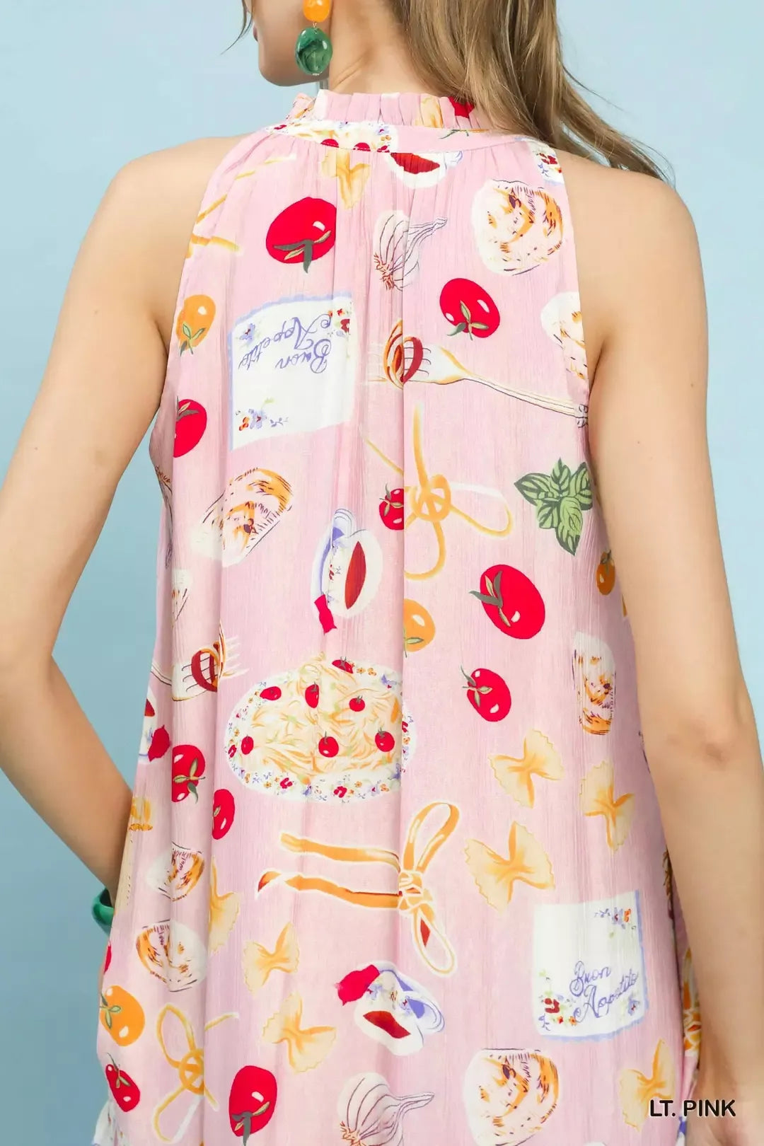 Light pink sleeveless dress with colorful fruit and cake pattern on a light blue background