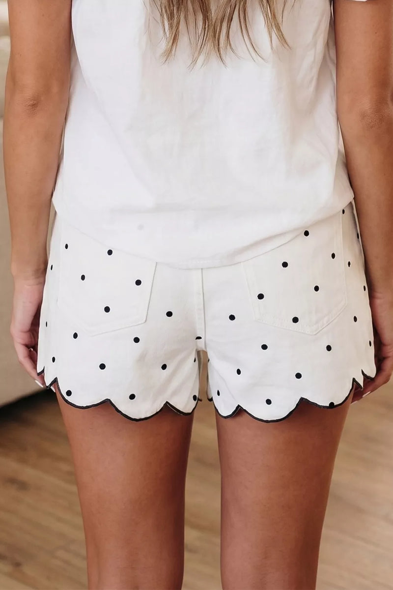 White shorts with black polka dots worn by a person indoors.