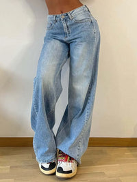 Person wearing light blue jeans with a neutral background