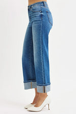 Blue jeans with rolled-up cuffs on a white background