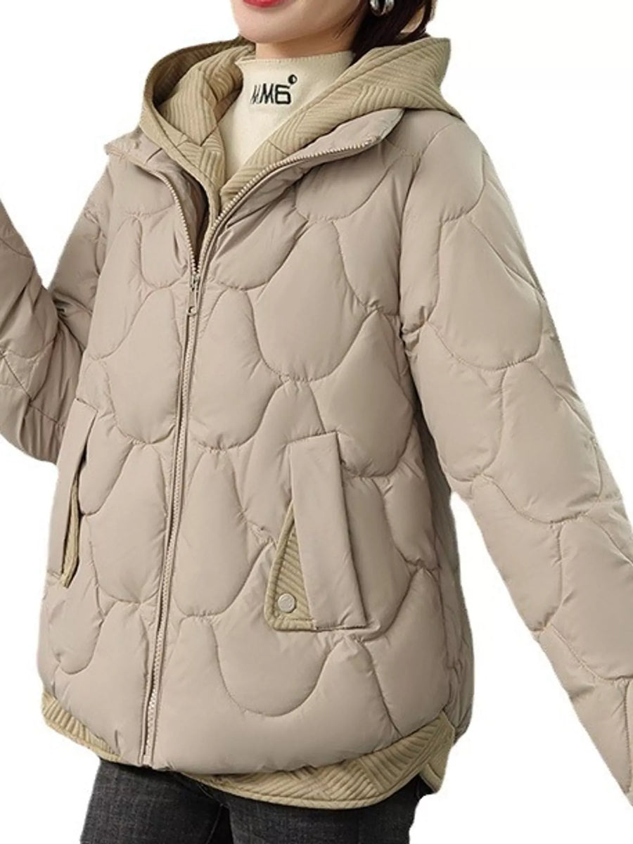 A beige quilted puffer jacket with a hood and zippered front, shown on a model against a plain white background.